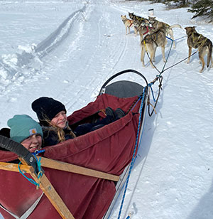 Two kids with a dog sled