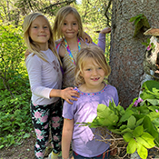 Three girls next to tree