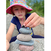 student stacking rocks to create a zen figure