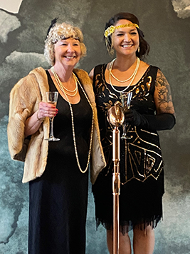 Two ladies holding champagne glasses at the gala