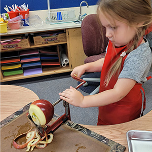 student peeling an apple