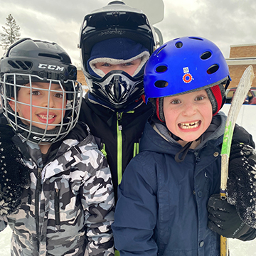 Three happy student in ice hockey gear outside