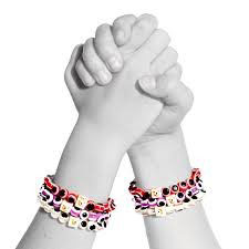 Two hands clasped together wearing bracelets