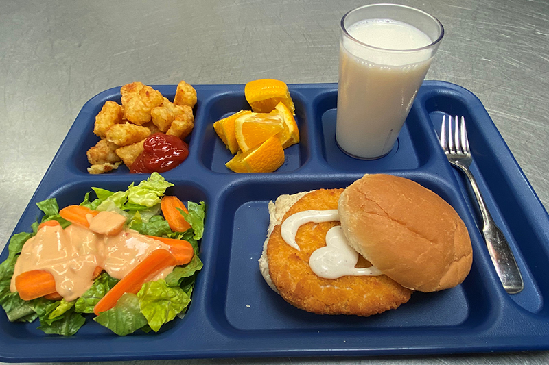 Crispy Chicken Sandwich, tater tots, green salad, fruit, and glass of milk