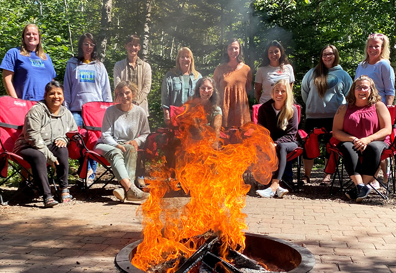 Staff members sitting around a campfire