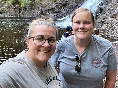 Two ladies smiling by the waterfall